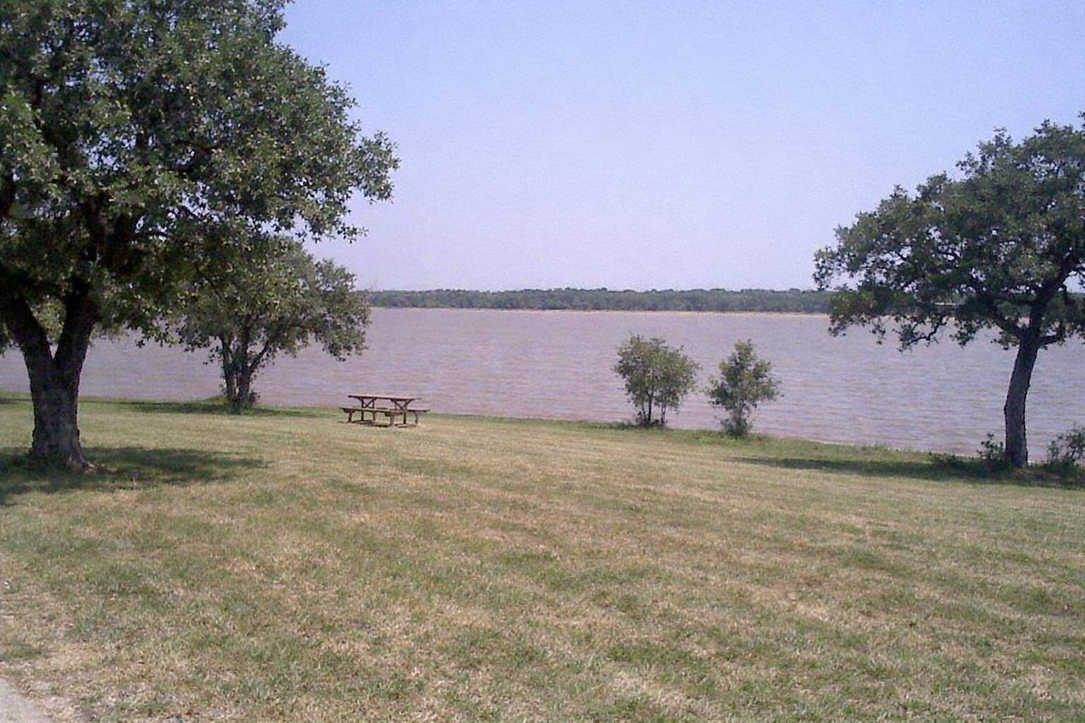 A lakeside park with trees at the water