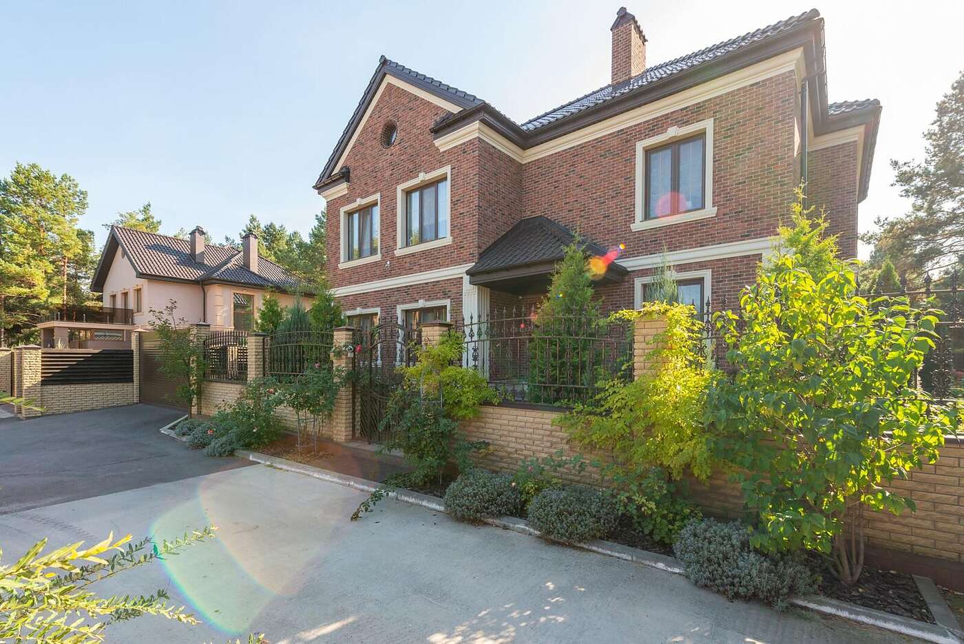 A two-story brick house with a composition shingle roof in a North Texas subdivision